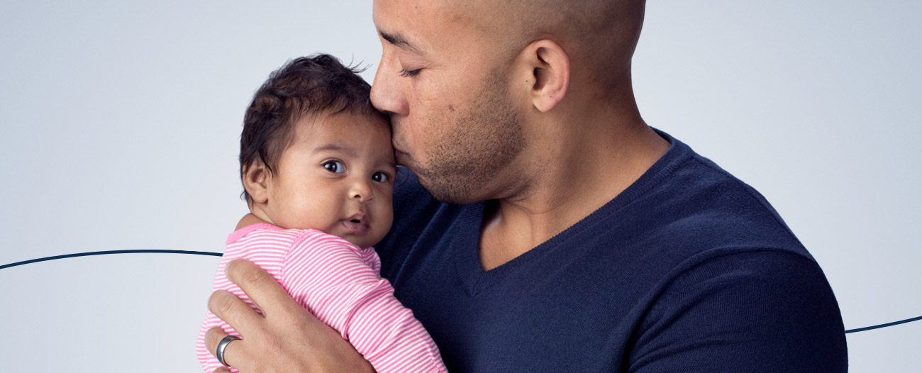 Dad holding and kissing his baby