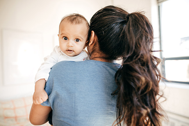 Mother with her baby over her shoulder