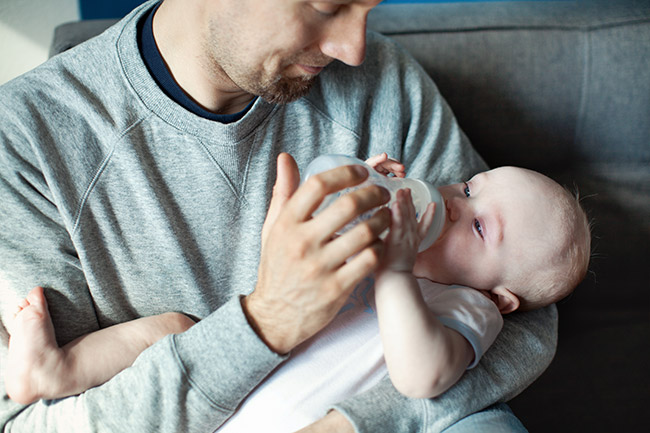 Dad feeding his baby with a bottle