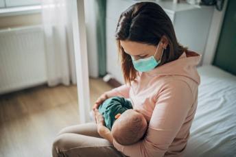 Mom with Mask Holding Baby